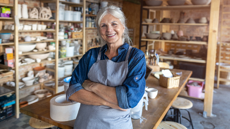 Portrait of senior female pottery artist in her art studio.